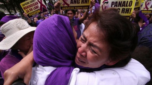 Supporters of birth control celebrate in front of the Supreme Court's summer residence in Baguio City, north of Manila, on Tuesday. 