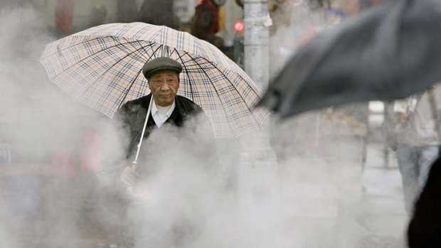A pedestrian walks through a cloud of steam in New York's Chinatown.