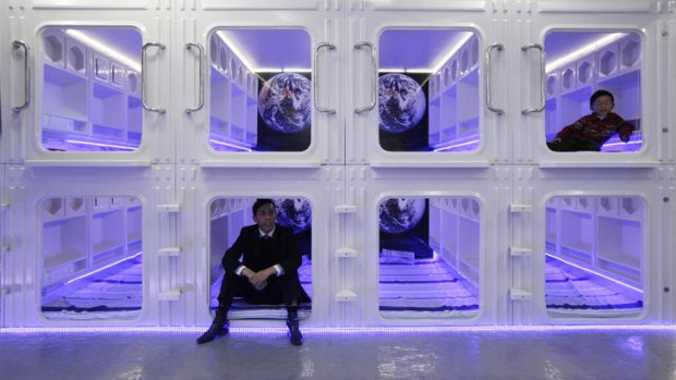 "Capsule bed" manufacturer Eric Wong, left, and his son Osbert pose inside a modified capsule-like bedroom imported from Japan in his showroom in Hong Kong.