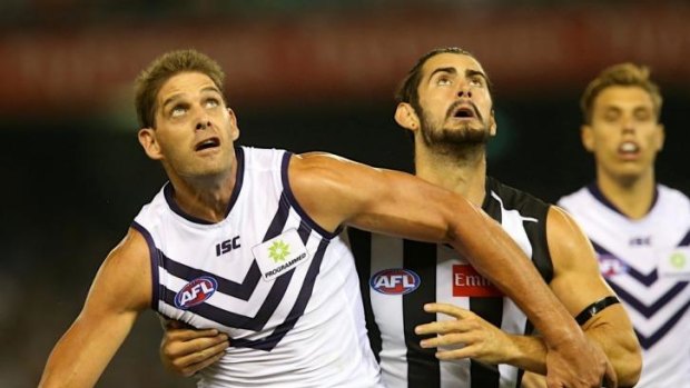 Brodie Grundy (right) battles with Aaron Sandilands in the ruck in the 2014 season opener.