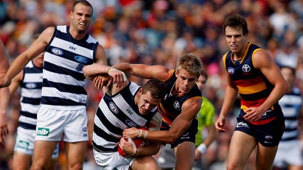 David Mackay of the Crows puts the squeeze on Joel Selwood of the Cats when the teams met in round seven.