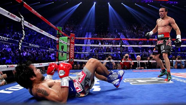 Manny Pacquiao is knocked down by Juan Manuel Marquez in the third round.