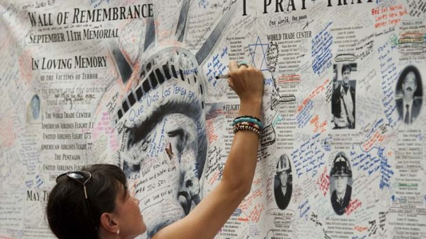 A woman writes a message on the wall of remembrance memorial near the World Trade Center on September 10, 2011 in New York. US President Barack Obama on Saturday called for a "heightened state of vigilance and preparedness" as the United States marks the 10th anniversary of 9/11 under a terror threat, the White House said.   AFP PHOTO/DON EMMERT