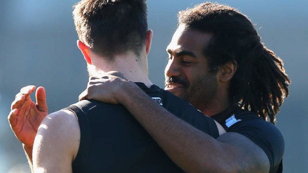 Harry O'Brien hugs teammate Nathan Brown during training on Tuesday.