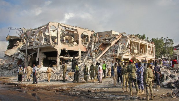 Somali security forces and others search for bodies near destroyed buildings in Mogadishu on Sunday.