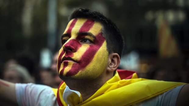 A man with the Catalan flag painted on his face attends a demonstration downtown Barcelona, Spain.