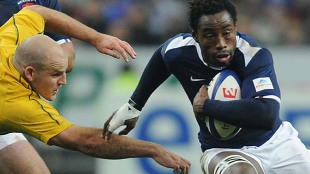 French flanker Fulgence Ouedraogo charges past Australian hooker Stephen Moore.