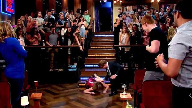 A horrified <i>Late Late Show</i> host James Corden rushes to Katie Couric's side. Check out the mixed faces in the audience.