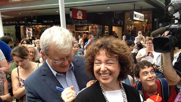 Kevin Rudd signs an autograph for a young fan as he walks through Brisbane's Queen Street Mall.