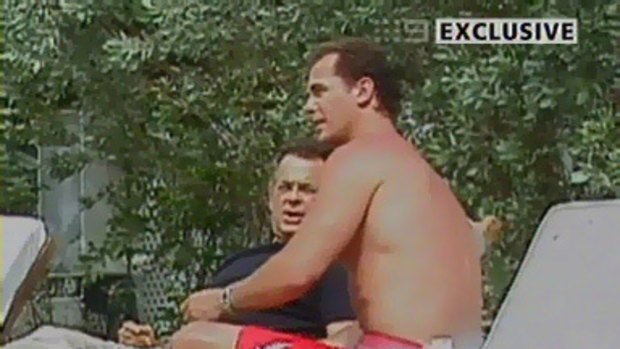 The office: Wayne Carey meets a man said to be his legal advisor beside a pool at a Miami hotel.