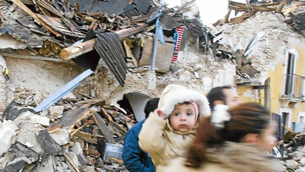 A woman carrying her child the morning after a quake struck Onna.