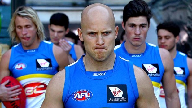 Gary Ablett of the Suns leads his players onto the field in round 19.