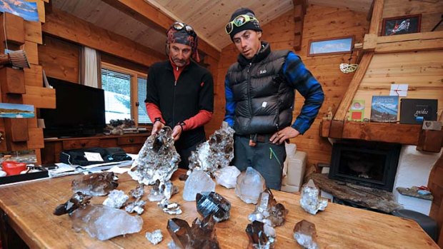 Stephane Dan, crystal hunting guide, and Alexandre Pittin, mountaineer and crystal hunter, look at some of the minerals they found in the Mont Blanc massif.