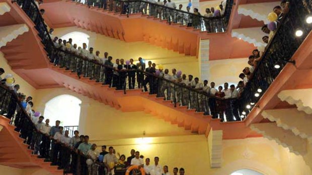 Hotel staff line the grand cantilever staircase under the hotel's iconic red dome as the Taj Mahal Palace and Tower hotel reopens in Mumbai. <i>Picture: AFP</i>