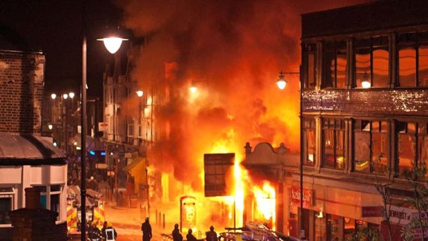 LONDON, ENGLAND - AUGUST 06:  Buildings burn on Tottenham High Road, London after youths protested against the killing of a man by armed police in an attempted arrest, August 6, 2011 in London, England. Twenty-nine-year-old father-of-four Mark Duggan died August 4 after being shot by police in Tottenham, north London. (Photo by Matthew Lloyd/Getty Images) *** BESTPIX ***