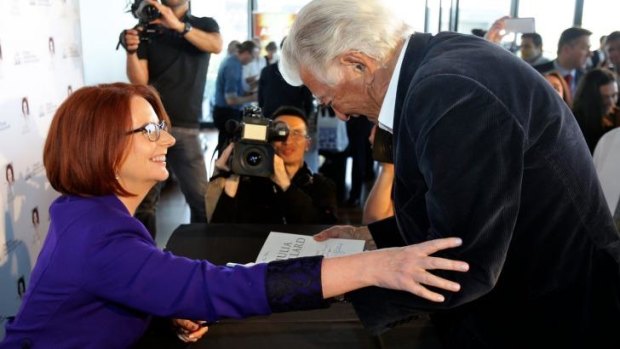 Julia Gillard reaches out to former prime minister Bob Hawke at the launch of her book in Sydney.