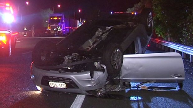 The couple’s car was clipped by a merging truck and then pushed along the motorway for several metres before it spun out of control, flipped and landed on its roof. Photo: Seven News.