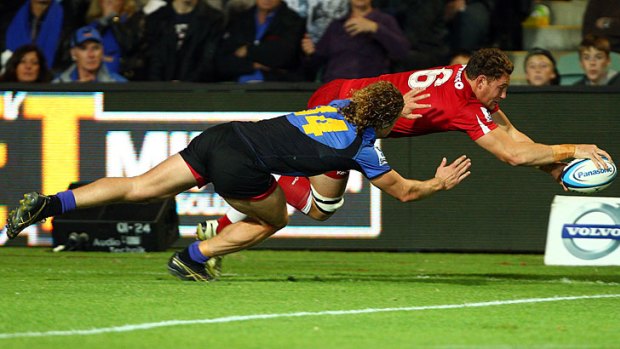 Scott Higginbotham of the Reds dives for a try.
