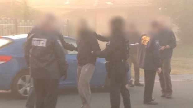 Australian Federal Police arrest a man during a raid on an Islamic store in Logan, south of Brisbane. 