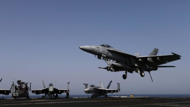 Action: An F/A-18E Super Hornet landing on the flight deck of the aircraft carrier USS George H.W. Bush (CVN 77), in the Persian Gulf.