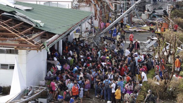 Residents queue up to receive treatment and relief supplies at Tacloban airport following Friday's Typhoon Haiyan that lashed this city and several provinces in central Philippines.