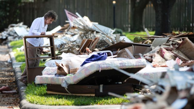Antoinette Porcarello views her flood-damaged possessions piled in the front yard in the aftermath of Hurricane Harvey in Houston. 