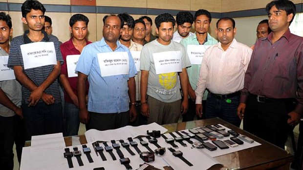 Bangladesh police parade alleged members of hi-tech exam cheats who use watch-like mobile phones to help examinees pass university and job recruitment tests.