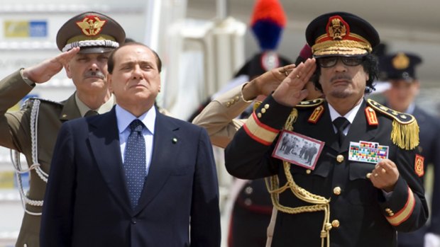 Libyan leader Muammar Gadhafi and Italy's Prime Minister Silvio Berlusconi stand at attention at Ciampino Airport in Rome.