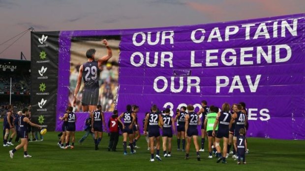 Fremantle players get set to run through an appropriately captioned banner before the game.