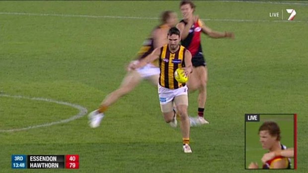 Essendon's Jake Melksham (background, right) was reported for this incident involving Hawthorn's Jarryd Roughead.
