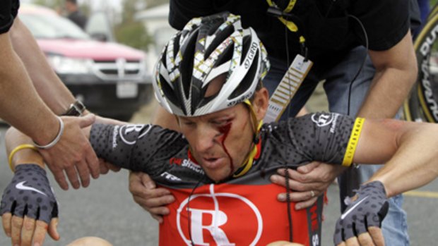 Lance Armstrong receives assistance after his crash during the fifth stage.