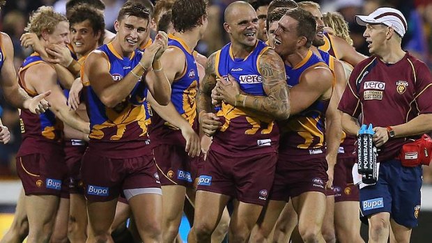 Ashley McGrath is mobbed by teammates after icing the Brisbane Lions' surprise win over Geelong at the Gabba.