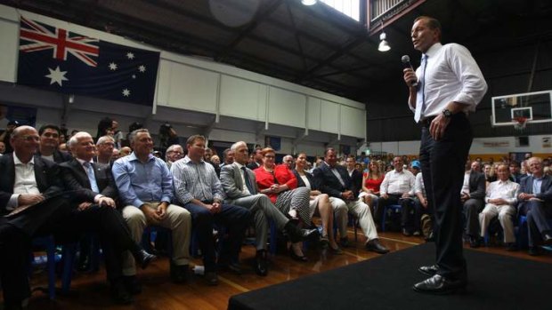 Tony Abbott speaks at the party rally at Auburn Basketball Centre while  Liberal heavyweights including Joe Hockey and  Malcom Turnbull look on.