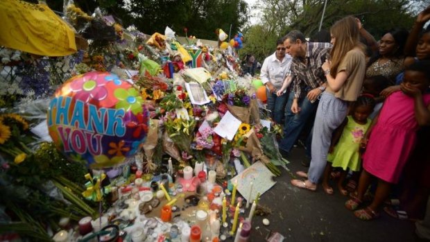 People pay tribute to Mandela outside his Houghton home in Johannesburg.