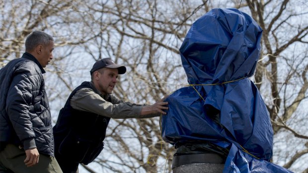 New York City Parks workers remove a moulded bust of Snowden that was erected by a group of anonymous artists in 2015.