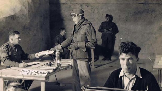 Service ... Major Hayman at his desk in a dugout outside Tobruk in 1941.
