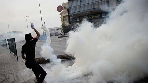 A Bahraini man throws a teargas canister fired by riot police this week.
