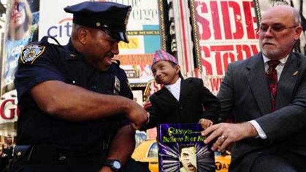 Khagendra Thapa Magar, 17, with a New York  policeman and Ripley's Edward Meyer in Times Square.