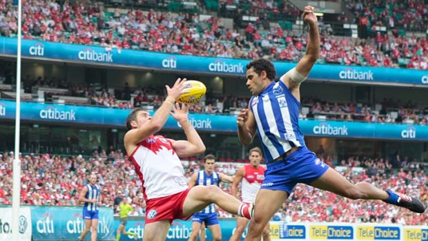 On song: Sydney's Craig Bird beats North Melbourne's Daniel Wells to the ball.
