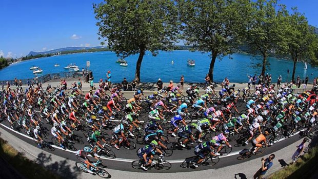 Riders make their way around Lake Annecy at the start of the 20th stage of the Tour de France.