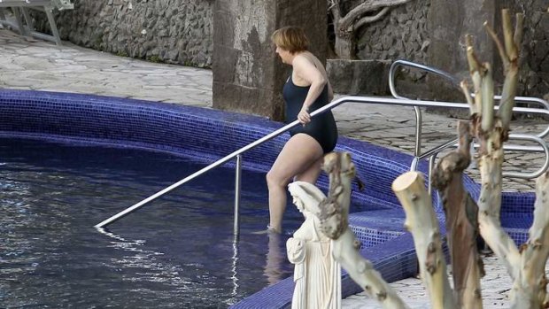 German Chancellor Angela Merkel enters a swimming pool at the Aphrodite thermal baths on the southern Italian island of Ischia.