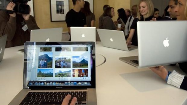 Journalists look at the new MacBook Pro notebook computers.
