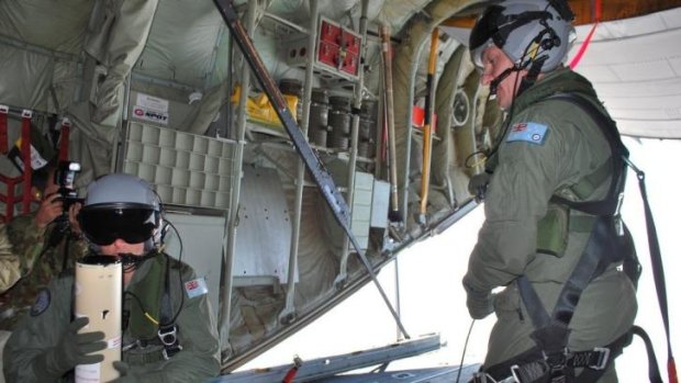Narrowing the search area ... Loadmasters Sergeant Adam Roberts (left) and Flight Sergeant John Mancey prepare to launch a water-activated buoy from the Hercules C-130J.