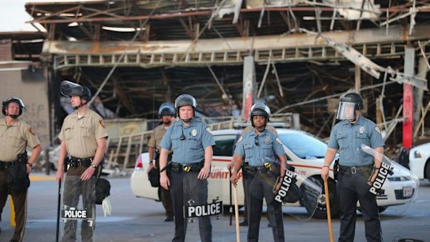 Policemen guard the Quick Trip convenience store which was burnt down.