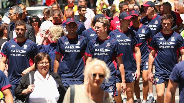 Demons players take part in the 'Walk Against Family Violence' around Melbourne.