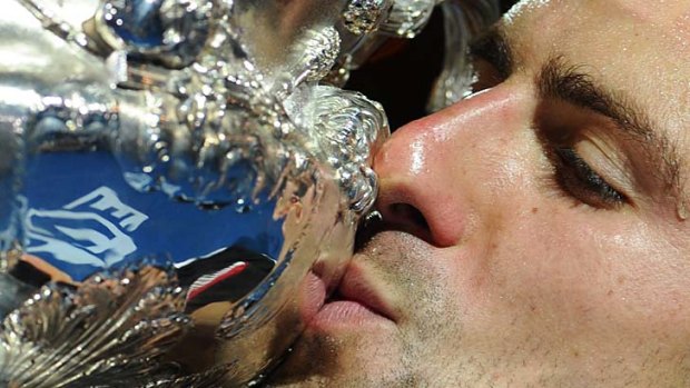Cup that cheers ... Novak Djokovich celebrates after claiming the men's trophy last year.