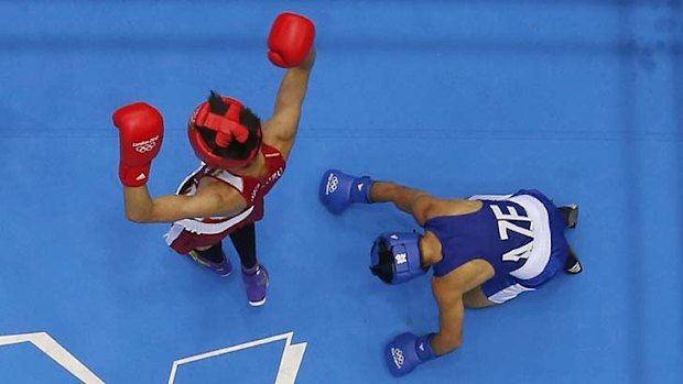 Japan's Satoshi Shimizu stands over Azerbaijan's Magomed Abdulhamidov after knocking him down.