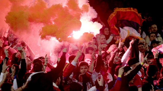 A flare lights up Serbian fans at last night's soccer friendly.