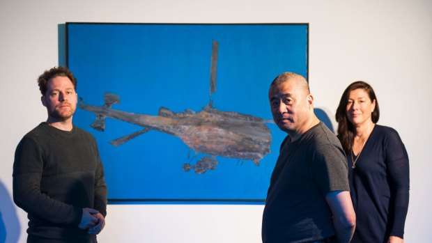 Painting titled 'Flying Machine' is the centrepiece of 'Zhang Peili: from Painting to Video' exhibition at the Australian National University. Pictured with co-curators Olivier Krischer and Kim Machan.