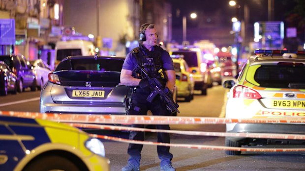 An armed police officer mans a cordon on the Seven Sisters Road at Finsbury Park.